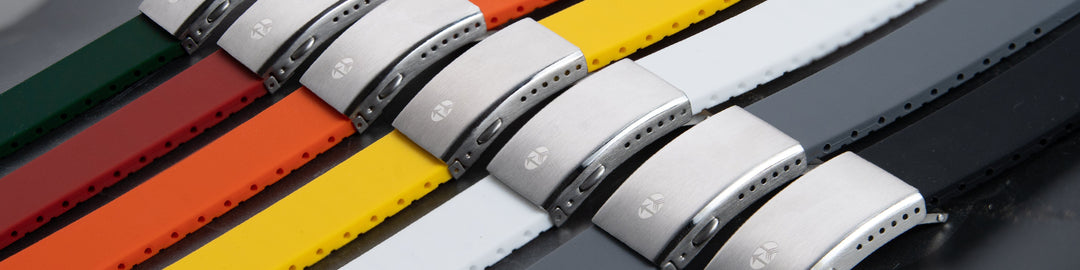 Row of custom-fit silicone watch straps in green, red, orange, yellow, white, and gray with steel clasps